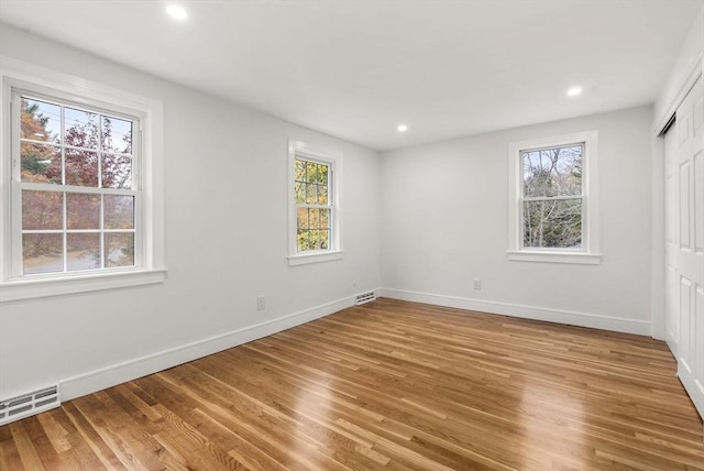 unfurnished bedroom with light wood finished floors, recessed lighting, and baseboards