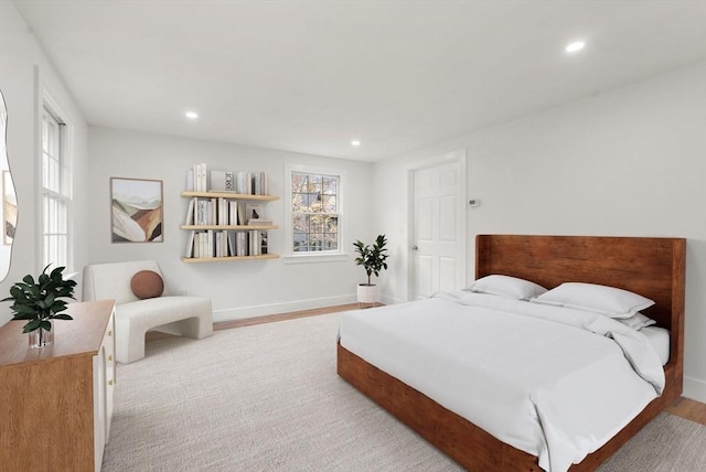 bedroom with multiple windows, wood finished floors, and recessed lighting