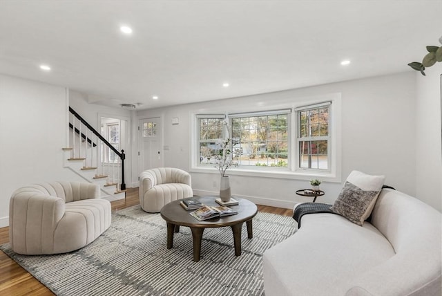 living room with baseboards, stairway, wood finished floors, and recessed lighting