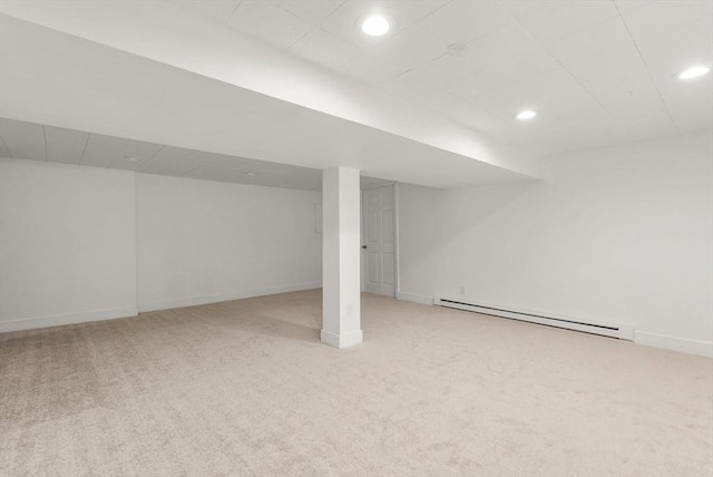 finished below grade area featuring a baseboard heating unit, recessed lighting, carpet floors, and baseboards