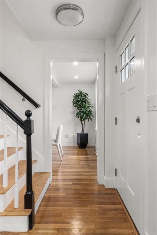 entrance foyer with baseboards, stairway, and wood finished floors