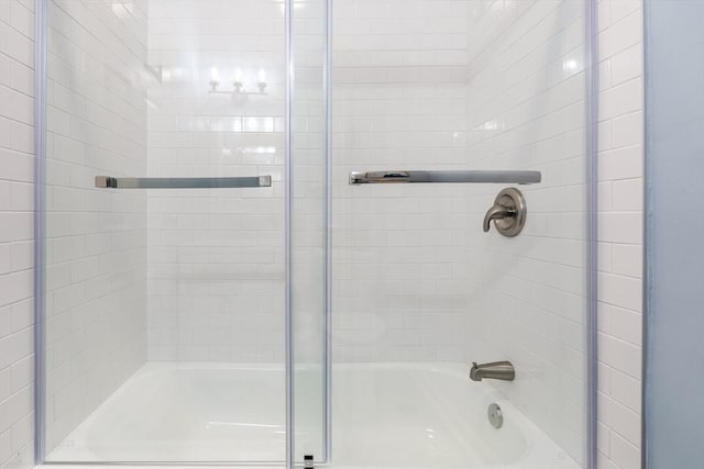 bathroom featuring combined bath / shower with glass door