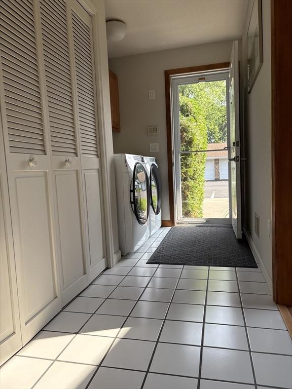 351-355 Main St Unit G, Easthampton, MA 01027 - laundry room with washer and dryer, cabinet space, and light tile patterned floors