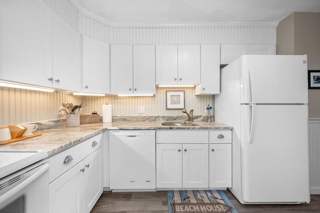 kitchen with white appliances, white cabinets, and a sink