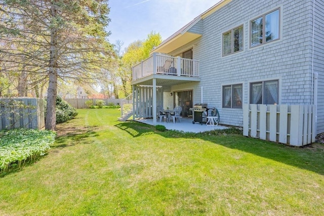 rear view of property with a lawn, fence private yard, a patio area, and a balcony