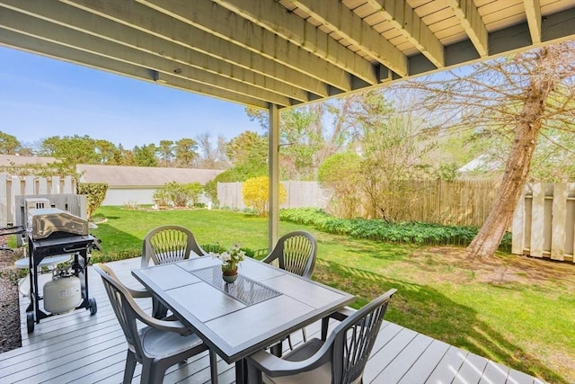 wooden deck with a fenced backyard, outdoor dining space, and a lawn