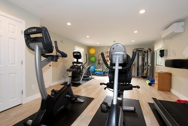 exercise room featuring recessed lighting, baseboards, a wall mounted AC, and light wood finished floors