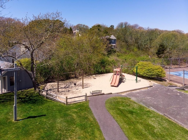 community play area featuring a yard and fence