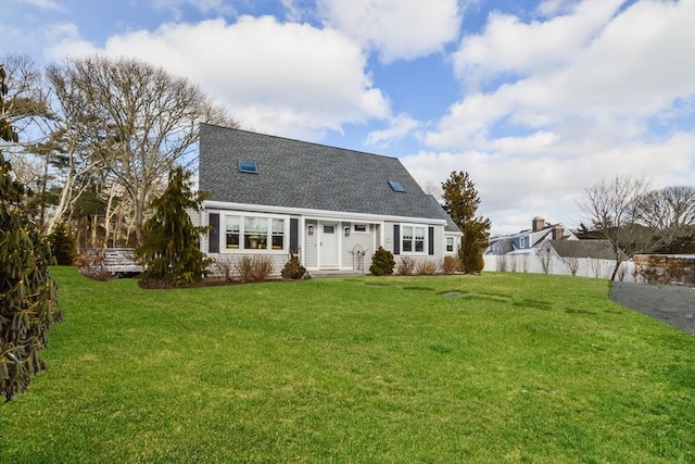 rear view of property featuring a lawn