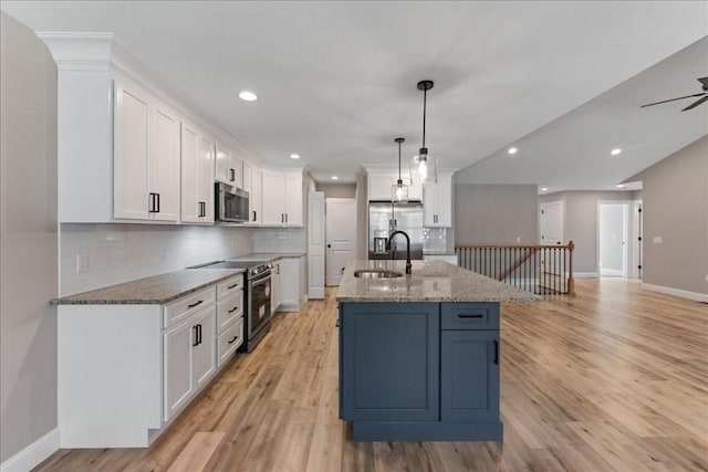 6 Nicols Way Unit 6, Easthampton, MA 01027 - kitchen featuring stainless steel appliances, white cabinetry, tasteful backsplash, light stone counters, and light wood-style floors