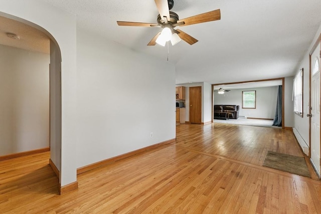 215 Pine Acre Rd, Springfield, MA 01129 - unfurnished living room with ceiling fan, light wood-type flooring, arched walkways, baseboard heating, and baseboards