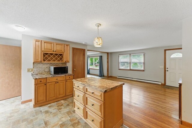 215 Pine Acre Rd, Springfield, MA 01129 - kitchen featuring baseboard heating, black microwave, light stone countertops, a textured ceiling, and tasteful backsplash