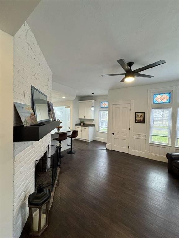 473 Massasoit Rd, Worcester, MA 01604 - entryway featuring a ceiling fan, baseboards, a fireplace, and dark wood-style floors