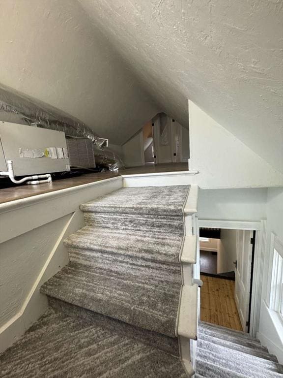 473 Massasoit Rd, Worcester, MA 01604 - staircase featuring a textured ceiling and vaulted ceiling
