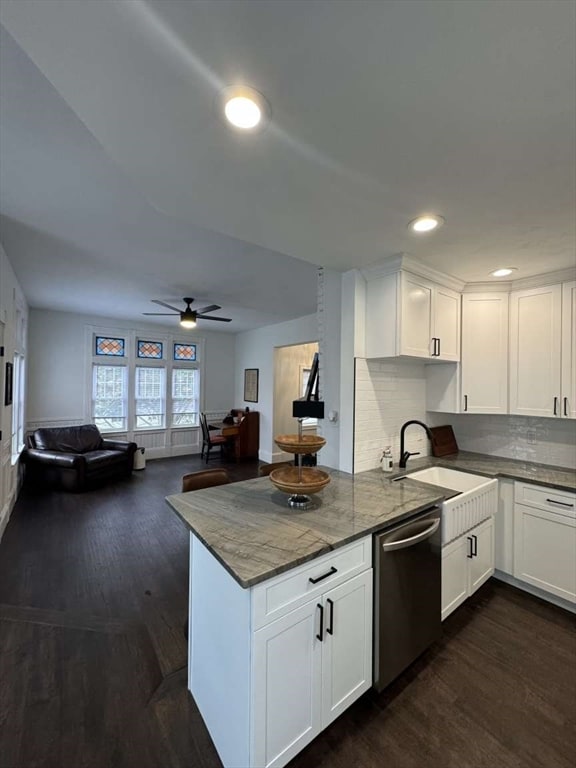 kitchen featuring white cabinets, stainless steel dishwasher, sink, and dark hardwood / wood-style floors