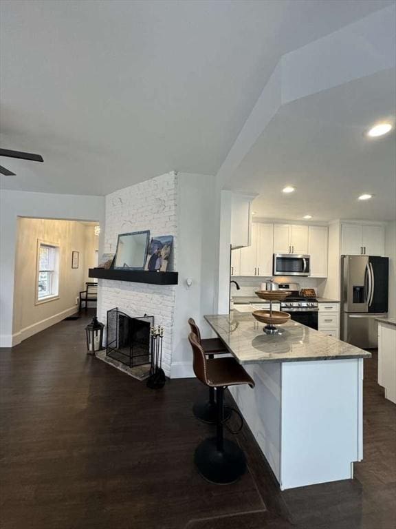473 Massasoit Rd, Worcester, MA 01604 - kitchen featuring white cabinets, a peninsula, stainless steel appliances, and baseboards