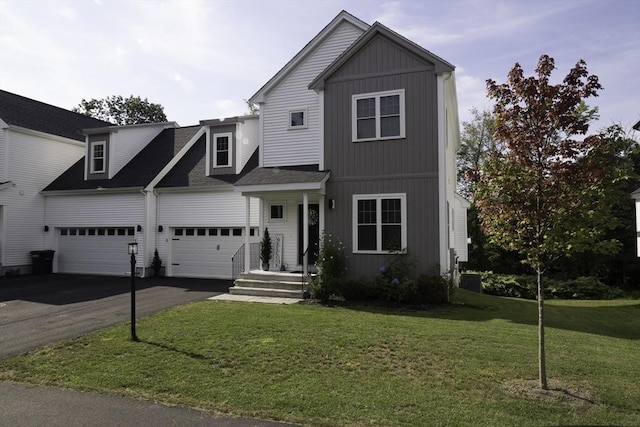 traditional home with a front lawn, a garage, driveway, and roof with shingles