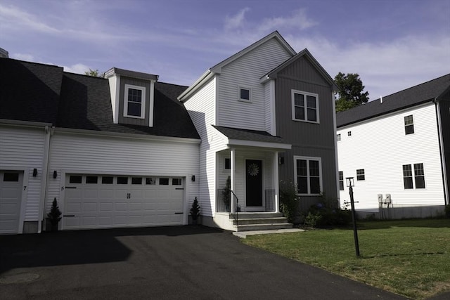 view of front of property with driveway, board and batten siding, an attached garage, a front yard, and a shingled roof