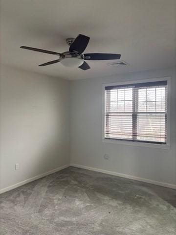 empty room with baseboards, a ceiling fan, and visible vents