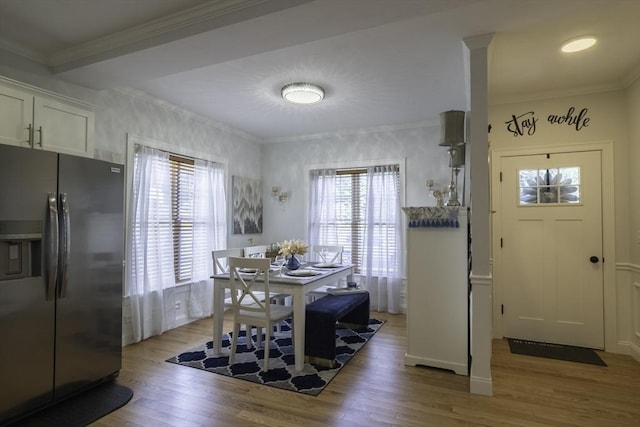 dining room featuring ornamental molding, a wealth of natural light, and light wood finished floors