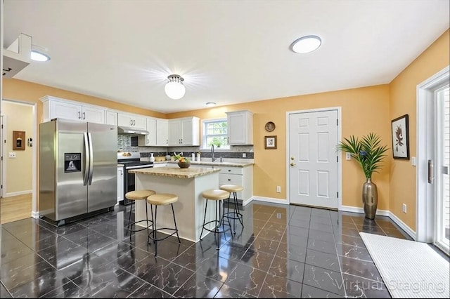 68 Ice Pond Dr, Northampton, MA 01062 - kitchen with appliances with stainless steel finishes, under cabinet range hood, a breakfast bar, a center island, and baseboards