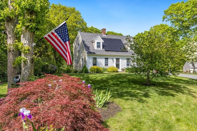 7 Hane Rd, Mashpee, MA 02649 - cape cod-style house with solar panels, a front yard, and a chimney