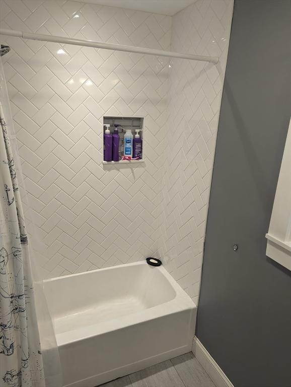 bathroom with shower / bath combo with shower curtain