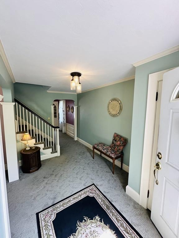 70 Sherman St, Quincy, MA 02170 - carpeted entryway featuring ornamental molding, stairway, arched walkways, and baseboards