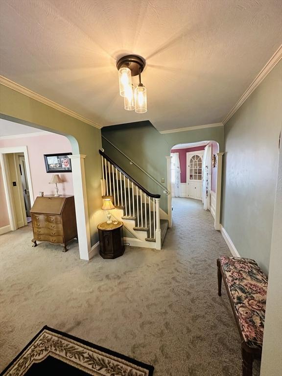 70 Sherman St, Quincy, MA 02170 - corridor with arched walkways, carpet floors, stairs, crown molding, and baseboards