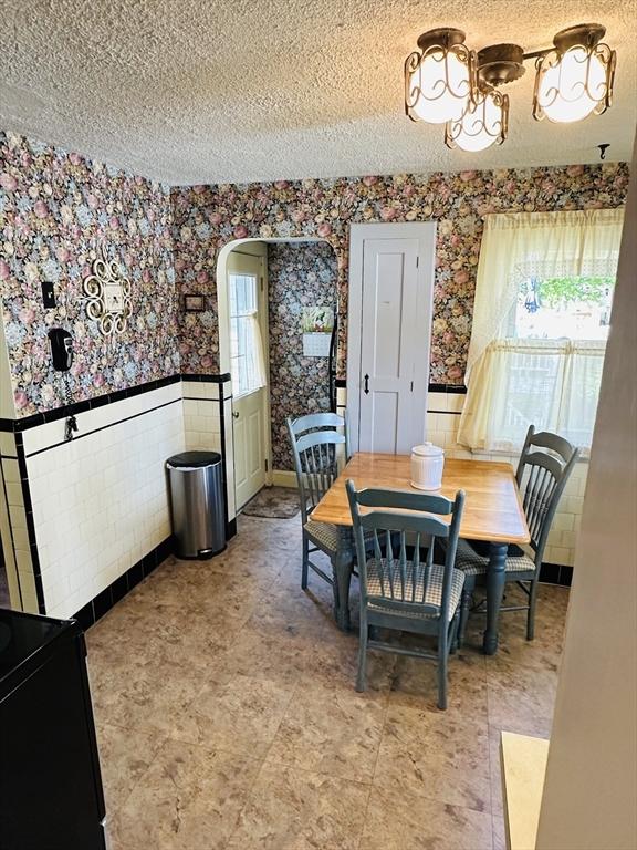 70 Sherman St, Quincy, MA 02170 - dining space featuring wallpapered walls, a wainscoted wall, and a textured ceiling