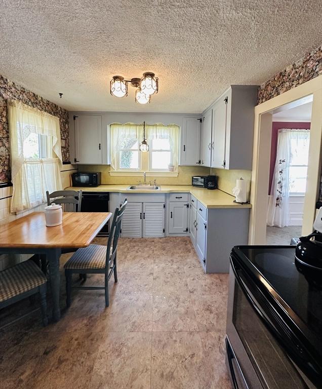 70 Sherman St, Quincy, MA 02170 - kitchen featuring black appliances, light countertops, a sink, and a textured ceiling