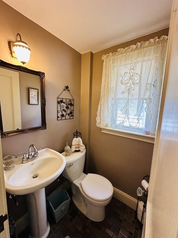 70 Sherman St, Quincy, MA 02170 - half bathroom featuring toilet, a sink, and baseboards