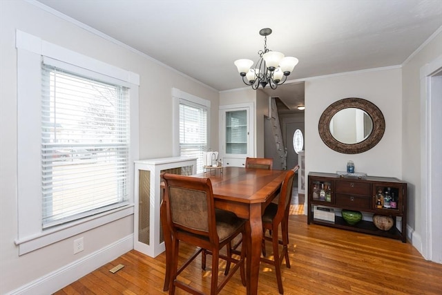 dining room with baseboards, crown molding, an inviting chandelier, and wood-type flooring