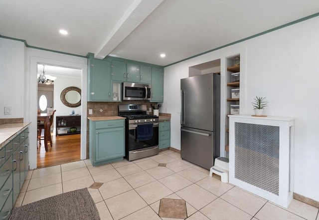 kitchen with green cabinets, light countertops, an inviting chandelier, light tile patterned flooring, and stainless steel appliances