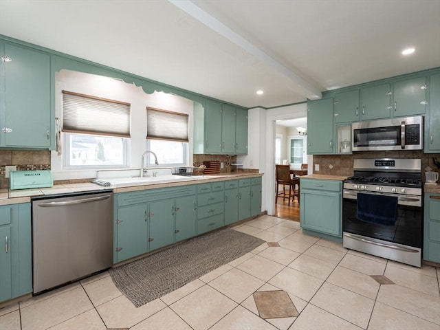 kitchen featuring a sink, stainless steel appliances, backsplash, and light tile patterned floors