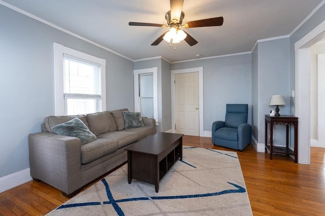 living area with baseboards, ornamental molding, and light wood finished floors