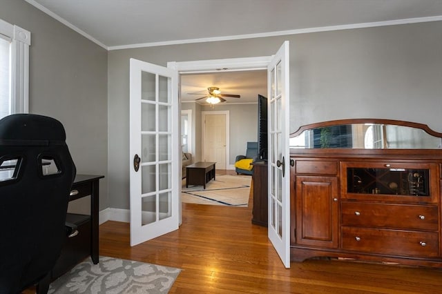 office space with french doors, crown molding, baseboards, and wood finished floors