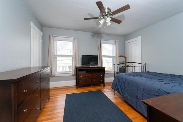 bedroom with light wood-type flooring, baseboards, and ceiling fan