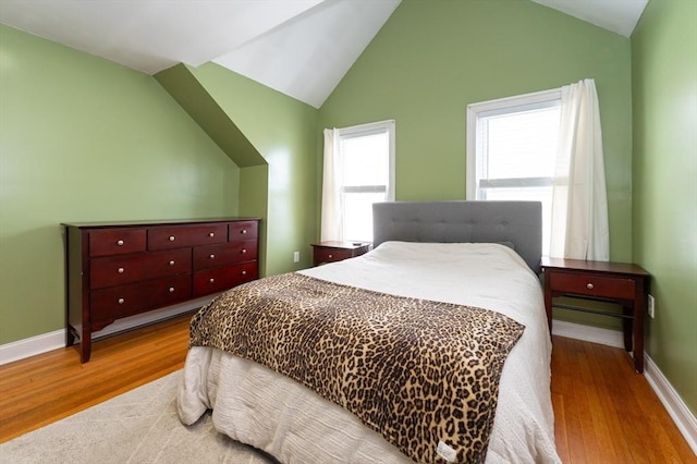 bedroom featuring vaulted ceiling, baseboards, and wood finished floors