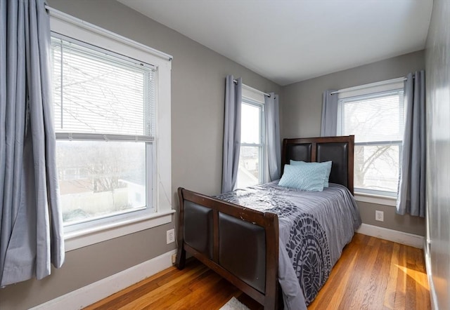 bedroom featuring baseboards and wood finished floors