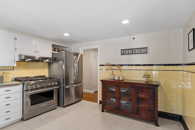 286 Laurel St, Melrose, MA 02176 - kitchen with stainless steel appliances, under cabinet range hood, tile walls, white cabinets, and recessed lighting