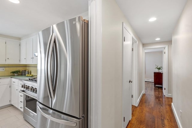 286 Laurel St, Melrose, MA 02176 - kitchen featuring appliances with stainless steel finishes, light countertops, white cabinetry, a baseboard radiator, and recessed lighting