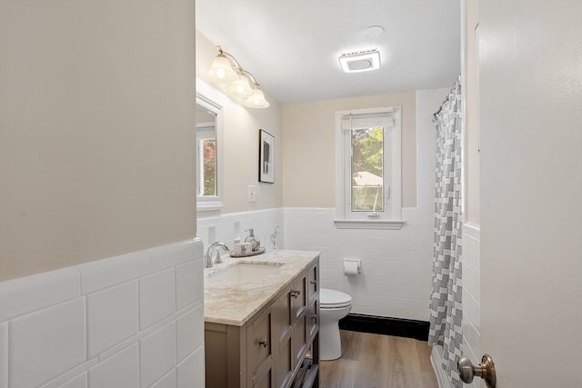 286 Laurel St, Melrose, MA 02176 - bathroom with tile walls, vanity, toilet, wainscoting, and wood finished floors