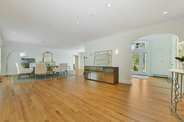 unfurnished living room with light wood-type flooring, arched walkways, baseboard heating, and ornamental molding