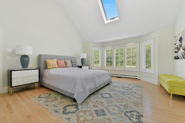 bedroom with a skylight, a baseboard heating unit, wood finished floors, high vaulted ceiling, and baseboards