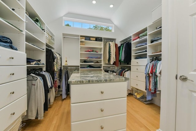 walk in closet with vaulted ceiling and light wood-style flooring