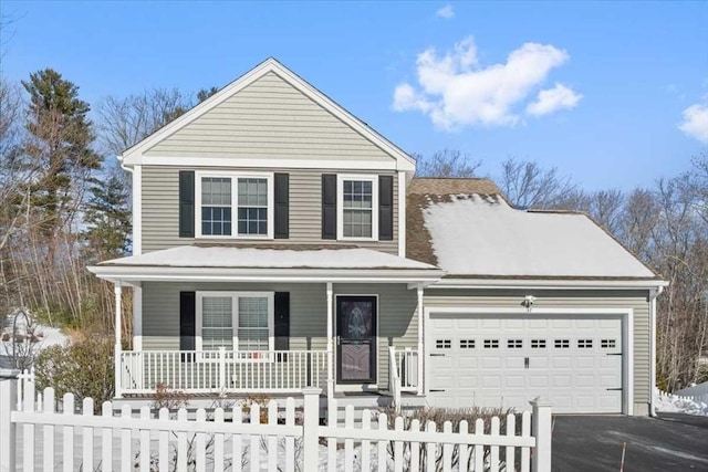 traditional-style home featuring an attached garage, a fenced front yard, a porch, and aphalt driveway