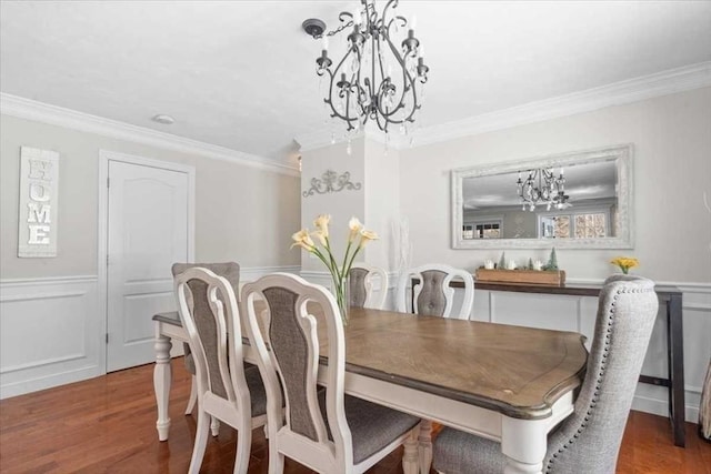 dining room featuring crown molding, wood finished floors, and wainscoting