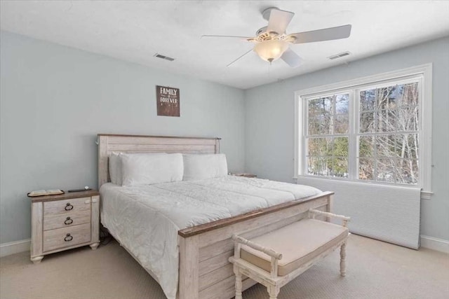 bedroom featuring a ceiling fan, visible vents, light carpet, and baseboards