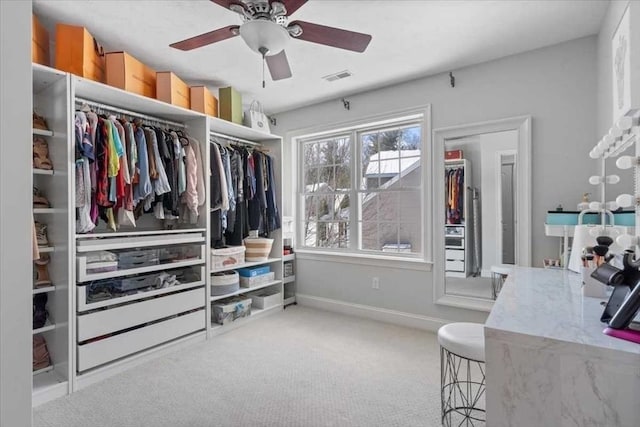 spacious closet featuring carpet, visible vents, and ceiling fan